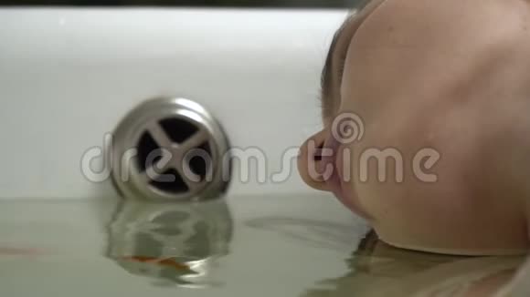 一个女人在金鱼游泳的浴室里的脸视频的预览图