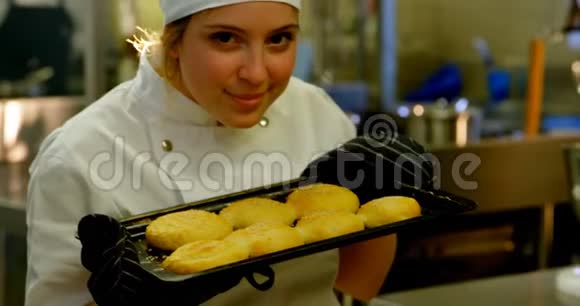 女厨师在厨房拿着一盘饼干视频的预览图
