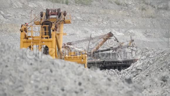 挖掘机在采石场铁路车内移动矿石重型设备视频的预览图