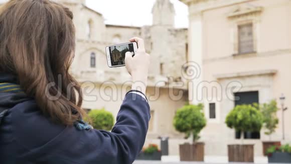 年轻女子正在用手机拍摄巴伦西亚的一栋大楼视频的预览图