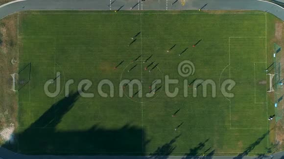 空中无人机镜头在球场上飞过足球运动员视频的预览图