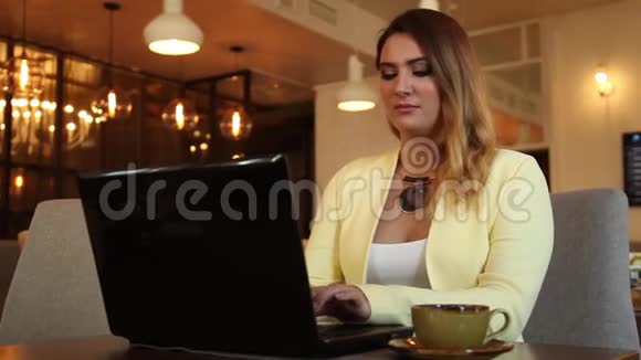 漂亮的女商人用移动电脑工作喝茶视频的预览图
