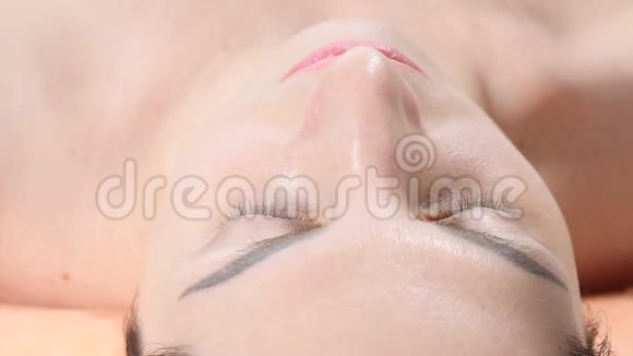 美容诊所的概念美容师在注射前用刷子将清洁面罩涂于女性面部视频的预览图