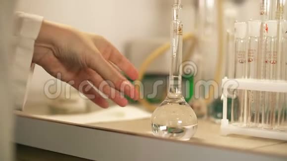 在实验室科学家中化学家用玻璃吸管和装有液体样品的烧瓶工作视频的预览图