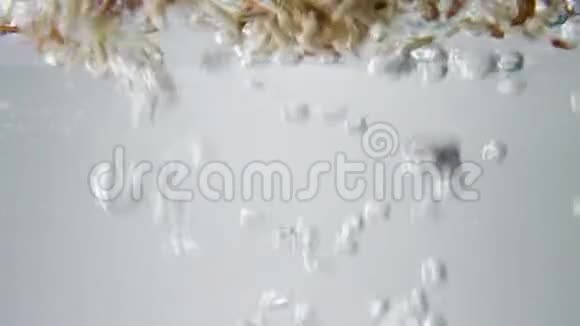 棕红米粒落入沸水中宏观观点视频的预览图