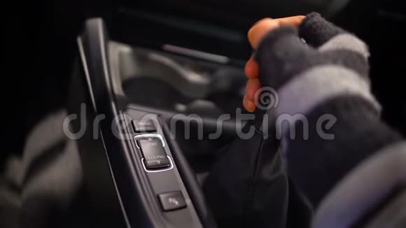 戴手套的人在昂贵的车里换变速箱劫车罪犯视频的预览图