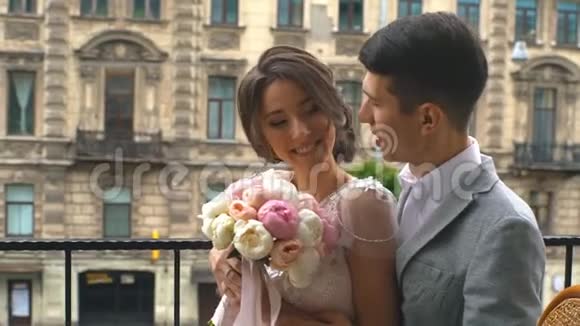 豪华酒店的阳台上新郎亲吻新娘的温柔视频的预览图