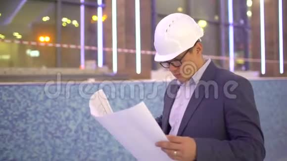 男拱工看在建建筑平面图年轻的白种人建筑工程师视频的预览图