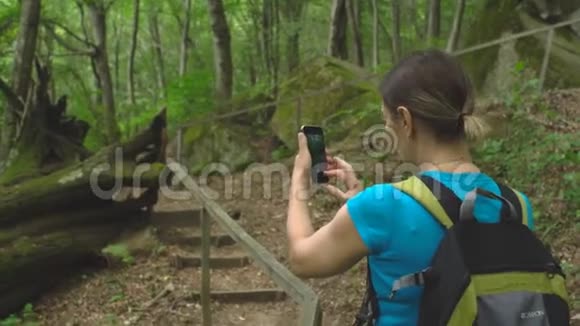 徒步旅行美女与背包制作照片智能手机丛林野生自然公园在山区旅游旅游视频的预览图