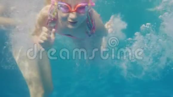 六岁的女孩在游泳池里游泳她妈妈帮助她水下视频视频的预览图