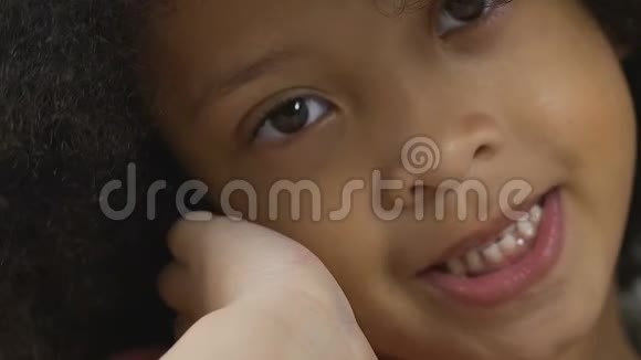 可爱的小黑人女孩微笑着看着镜头美丽的学龄前儿童视频的预览图