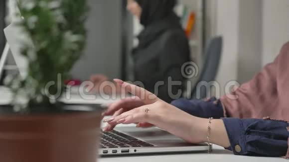 女性手在键盘上打字特写穿黑色头巾的女孩办公室商业工作妇女视频的预览图