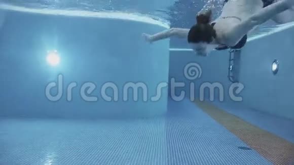 怀孕的女孩在游泳池里潜水视频的预览图