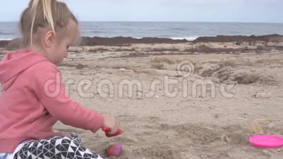 小女孩在沙滩上玩视频的预览图
