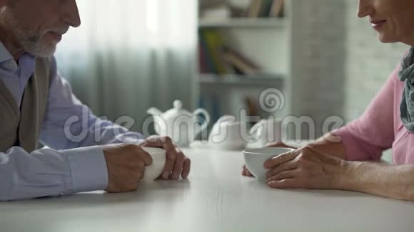 老两口端着茶坐在桌旁男人牵着女人的手幸福视频的预览图