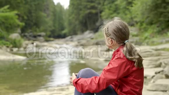 坐在河岸上的孩子视频的预览图
