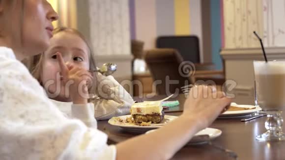 侧景一个可爱的年轻妈妈和一个可爱的小女儿一起吃饭视频的预览图
