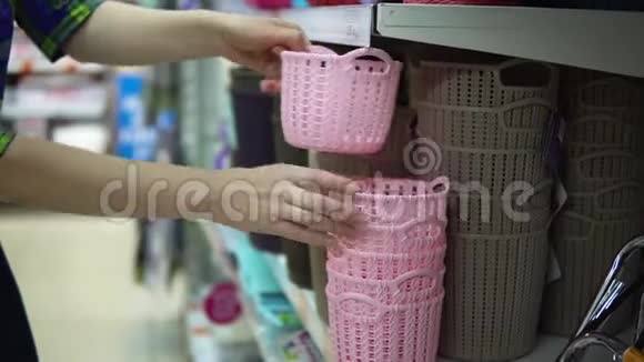 一个年轻的女人为超市里的东西选择和购买塑料篮子视频的预览图