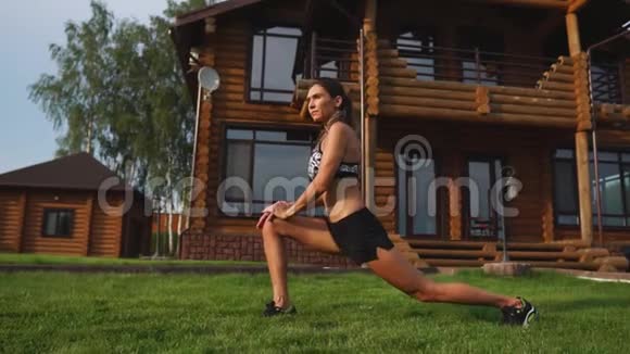 一位身材苗条穿着运动服的美女正准备在家附近的草坪上开始训练视频的预览图