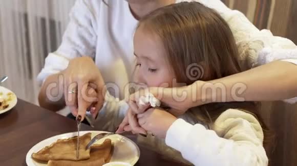 侧景一个可爱的年轻母亲和一个可爱的小女儿一起吃视频的预览图