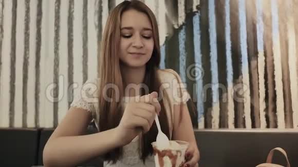 年轻漂亮的女孩正在咖啡馆里吃冰淇淋在学习期间休息视频的预览图