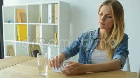 沮丧的年轻女人吃药视频的预览图