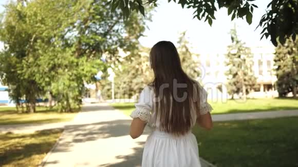来追我姑娘绕城跑慢动作带背包的女孩戴着耳机去公园听视频的预览图