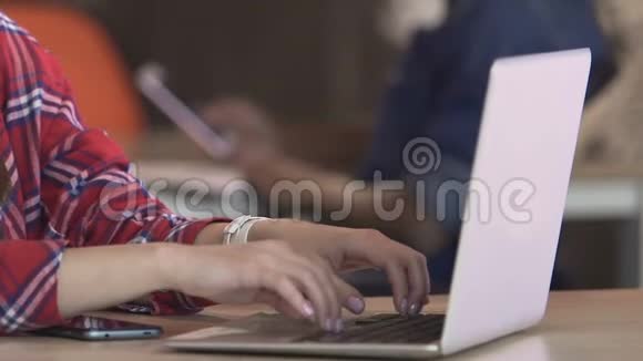 女学生在校园图书馆的笔记本电脑上工作或在咖啡厅网上聊天视频的预览图