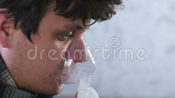 使用雾化器和吸入器进行治疗病人通过吸入面罩吸入特写面部侧视视频的预览图