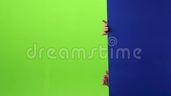 戴着圣诞帽的小男孩出现在黑板的一侧双手握在绿色的屏幕上慢慢视频的预览图