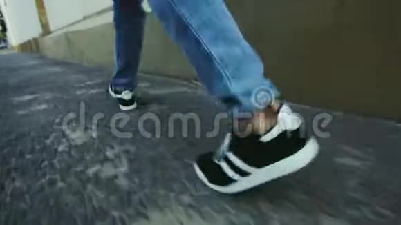 穿着运动鞋走在柏油马路上的家伙在城市中行走的人的腿视频的预览图