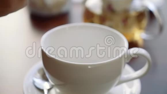 女孩的手把糖放在一杯茶里视频的预览图