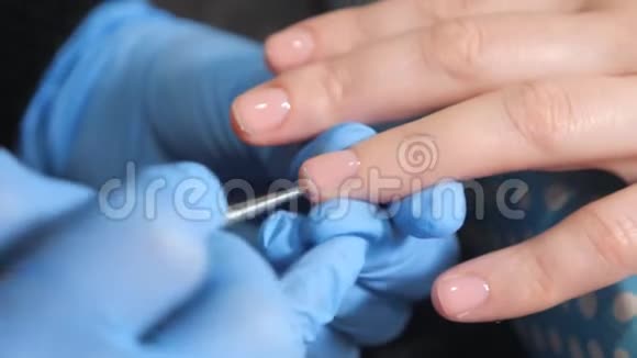 美容师将指甲油涂在美甲沙龙的女性指甲上视频的预览图