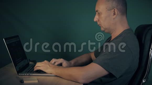人在笔记本电脑上浏览互联网深夜人们坐在桌旁上网学生寻找视频的预览图