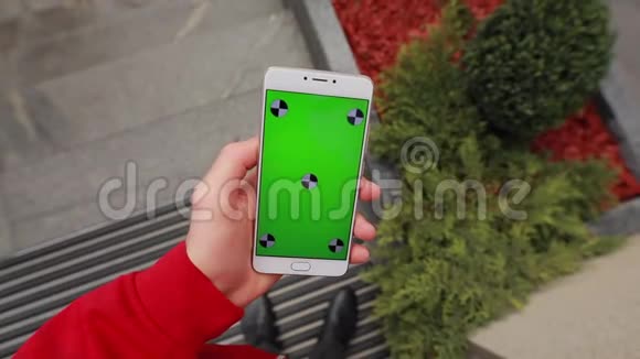 第一人称视图城市男性手中空白绿色智能手机屏幕视频的预览图