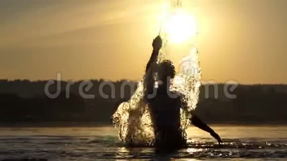 快乐的人在日落时举起湖水在邋遢中娱乐视频的预览图