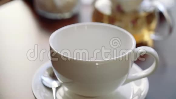 女孩的手把糖放在一杯茶里视频的预览图