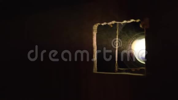 电影放映机发出的光穿过洞视频的预览图