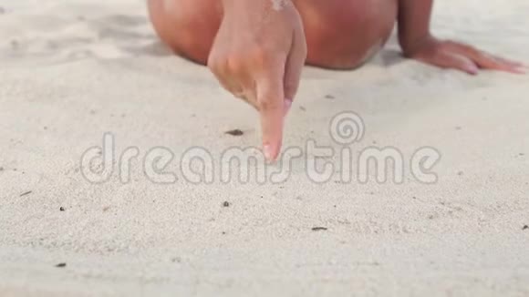 女人手牵着心在沙子上靠近慢动作女指画心沙上夏滩爱情视频的预览图