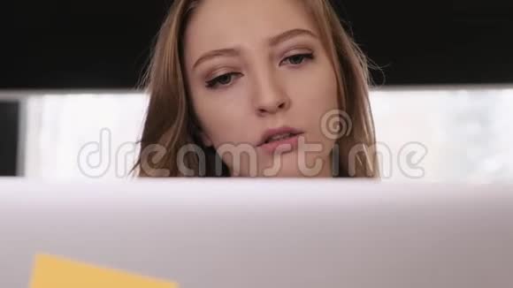 一个漂亮的金发女孩穿着一件白色的商业衬衫的肖像她体贴地工作一个想法出现在视频的预览图