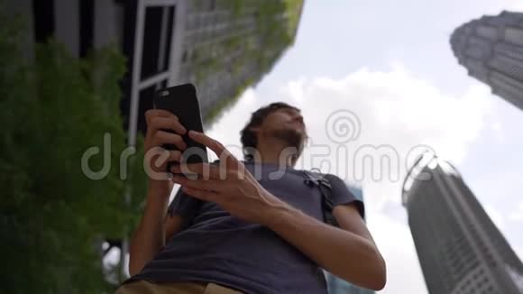 一位年轻女子在市中心使用智能手机背景是摩天大楼视频的预览图