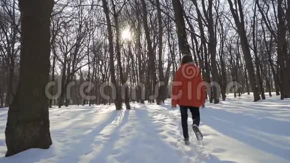 男孩在冬季公园慢跑视频的预览图