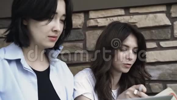 两个年轻女人带着笔记本电脑在户外工作视频的预览图