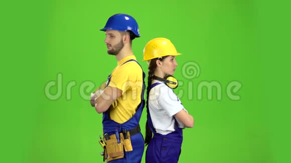 两个建筑工人背靠背站着手指伸直绿色屏幕视频的预览图