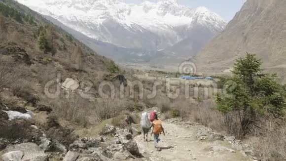 带着导游的游客正在尼泊尔马纳斯鲁地区喜马拉雅山徒步旅行视频的预览图