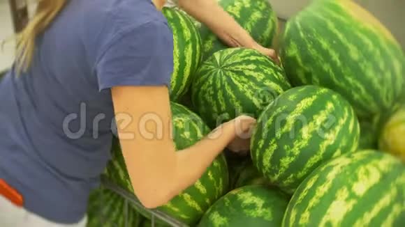 超市里的女人在水果和蔬菜区挑选西瓜4k视频的预览图