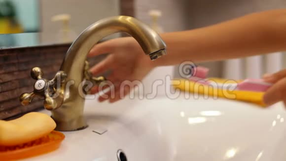 儿童洗牙刷和在浴室水龙头上漱口视频的预览图