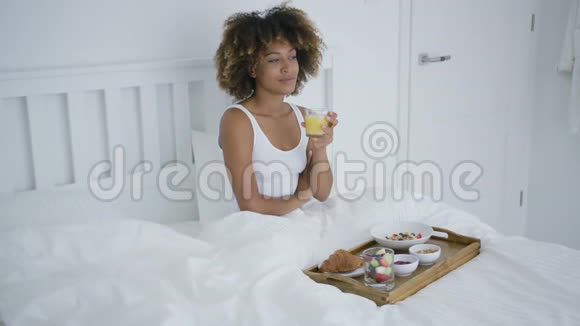 知足的女人在床上享受早餐视频的预览图