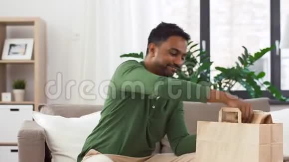 微笑的印度男人在家解外卖视频的预览图