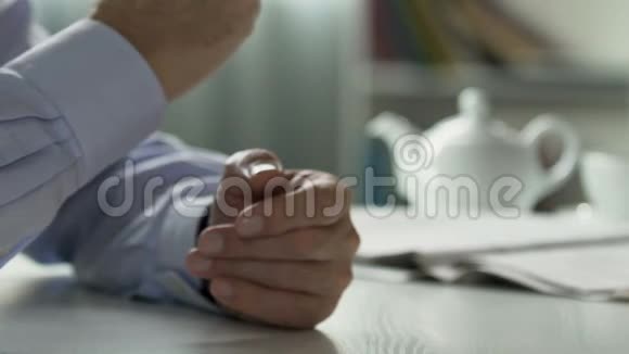 男人摘下眼镜坐在客厅的桌子上养老改革计划视频的预览图